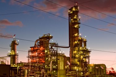 A picture of an oil refinery, taken either at dawn or dusk.