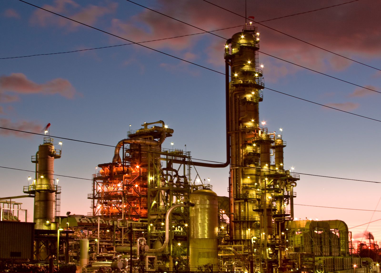 A picture of an oil refinery, taken either at dawn or dusk.